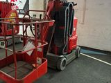 une paire de ciseaux rouges dans un entrepôt, avec une affiche accrochée au mur