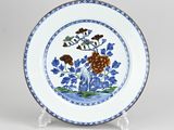 a blue and white plate with flowers and leaves on it