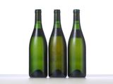 three bottles of wine are lined up in a row on a table