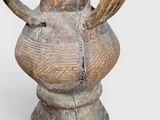 a wooden vase with a bird on top of it