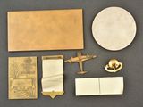 an image of a collection of brass objects including a plane, a book, and other items