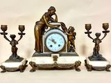une horloge posée sur une table à côté de trois bougies