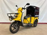 a yellow scooter that is parked in front of a white wall