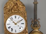 une horloge accrochée au mur à côté d'une bougie
