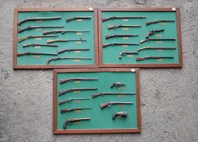 several guns displayed on a wall in a display case