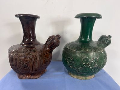two vases sitting on a blue cloth on a table