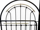 a bed with a metal frame and a metal headboard