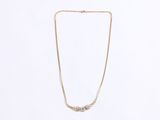 a gold chain necklace with a small white diamond on it