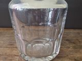 a clear glass bottle sitting on a wooden table