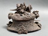 bronze statue of a bird on top of a box with flowers on it