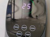 a digital clock that is on the wall next to a bed