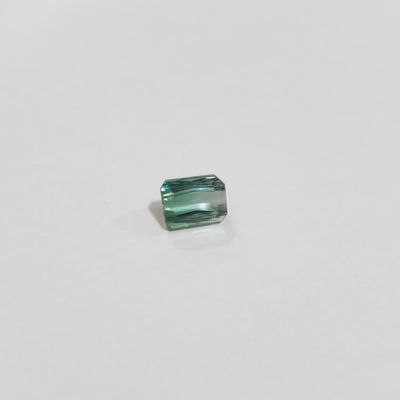 a green tourmaline stone on a white surface