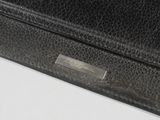 black leather purse with a metal clasp on a white surface