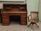 un bureau en bois avec une chaise à côté, dans une pièce