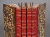 three books are stacked on top of each other on a gray surface