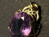 a close up of a purple stone on a black surface