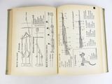an open book with a diagram of a gun on it