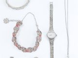 a lot of silver jewelry on a white surface