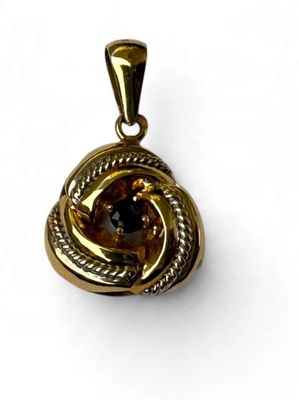 une image représentant un pendentif en or orné d'une pierre brune au centre