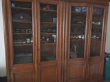 un grand meuble en bois avec des portes en verre dans une pièce