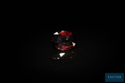 gros plan d'un diamant rouge sur une surface noire