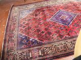 a rug on the floor with a chair in front of it