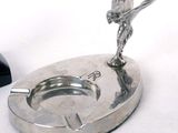 a silver ashtray with a bird on top of it