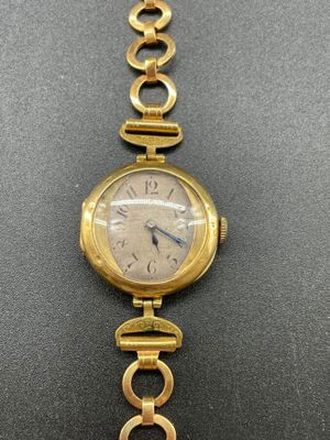 a close up of a wrist watch with a chain around it