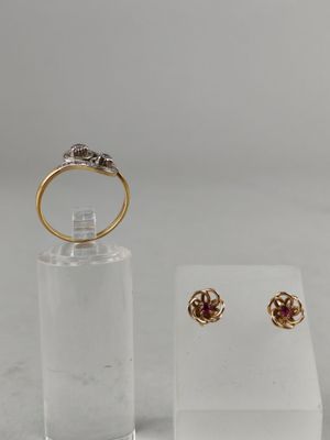 a close up of a pair of earrings and a ring on a display