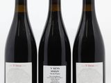 three bottles of red wine sitting next to each other on a white surface