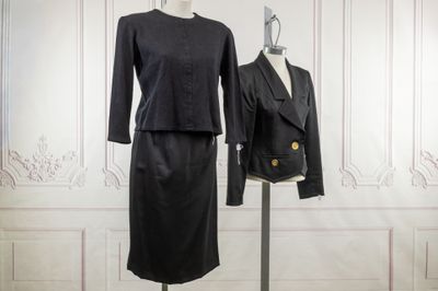a black dress and jacket on a mannequin stand