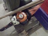 une tronçonneuse posée sur une palette dans un garage