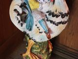 rooster figurine on a pedestal in front of a wooden door