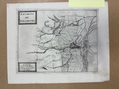 une vieille carte d'une ville dessinée sur une feuille de papier, à côté d'une autre feuille de papier