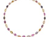 un collier de tourmalines multicolores et de perles sur fond blanc