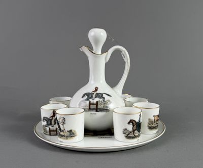 a white pitcher and six cups on a tray