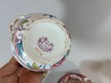 a person holding a cup and saucer in their hand