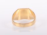 a close up of a gold ring on a white surface