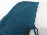 a teal colored knitted bag sitting on a white surface