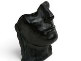 black sculpture of a man ' s head on a white background