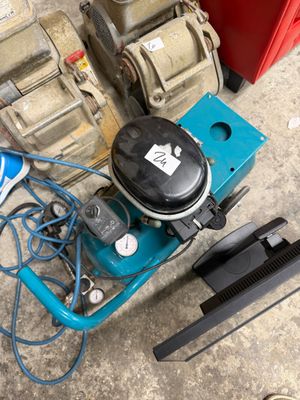 a blue machine that is on the ground next to a red box