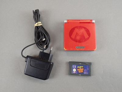a nintendo game console and a charger on a table