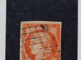 un timbre orange et noir sur lequel figure l'image d'une femme