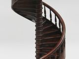 a wooden spiral staircase with a man on top of it