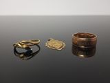 deux bagues et une bague posée sur une table, sur fond blanc