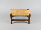 un petit tabouret en bois avec une assise tressée sur fond blanc