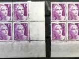 deux timbres représentant le visage d'une femme, posés sur une table