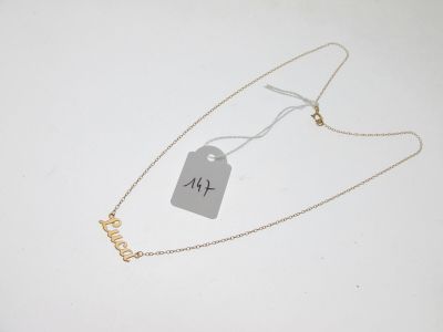 un collier en or avec un pendentif sur lequel est inscrit « love »