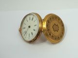 a gold pocket watch with roman numerals on it