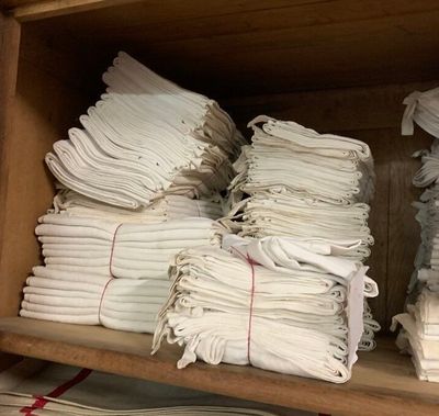 plusieurs piles de serviettes blanches pliées sur une étagère dans un magasin